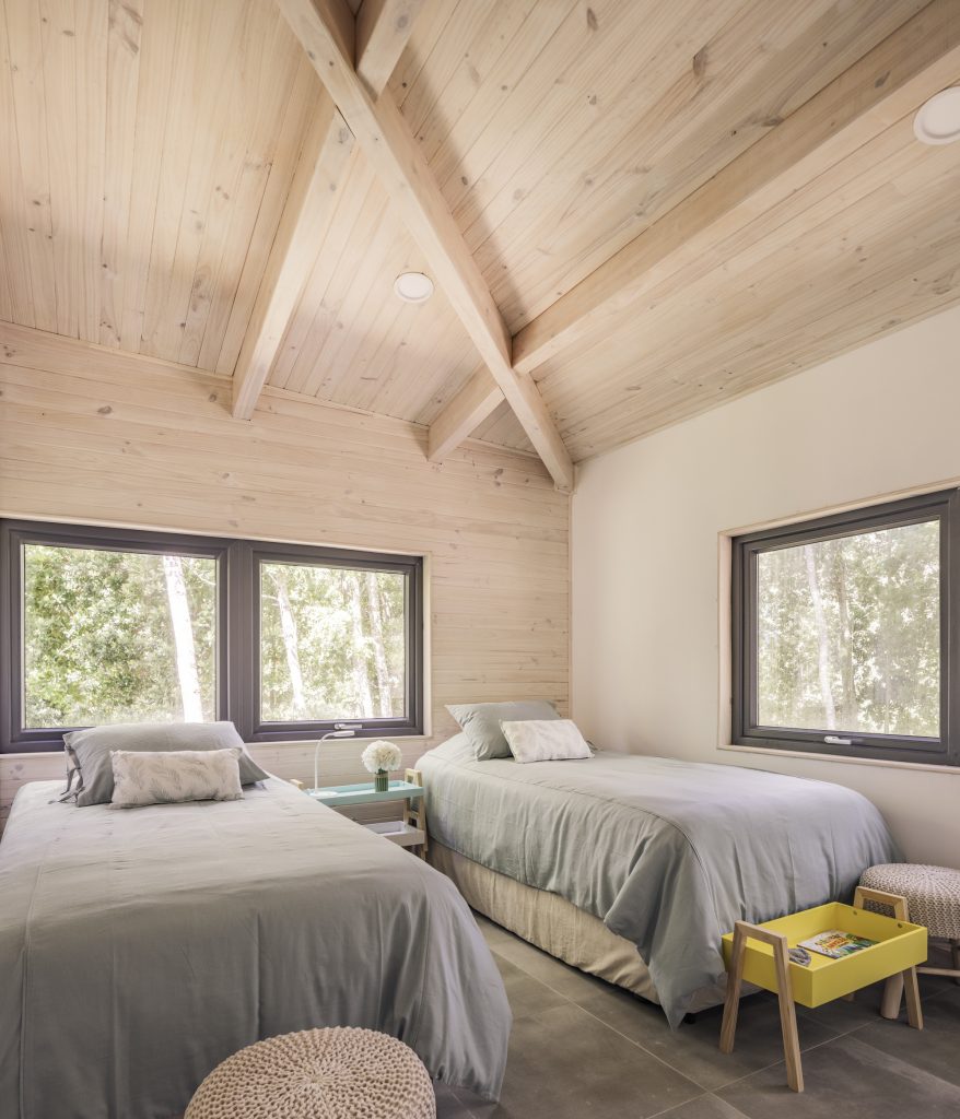 Forest House – Otroška spalnica pod lesenim stropom.
