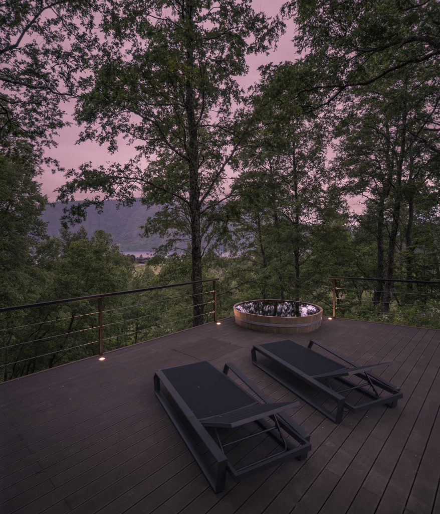 Forest House – Zunanja lesena terasa s pogledom v krošnje.