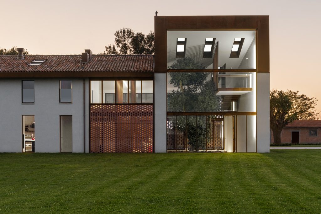 Greenary Residence – Visoka zastekljena fasada ob drevesu v notranjosti.