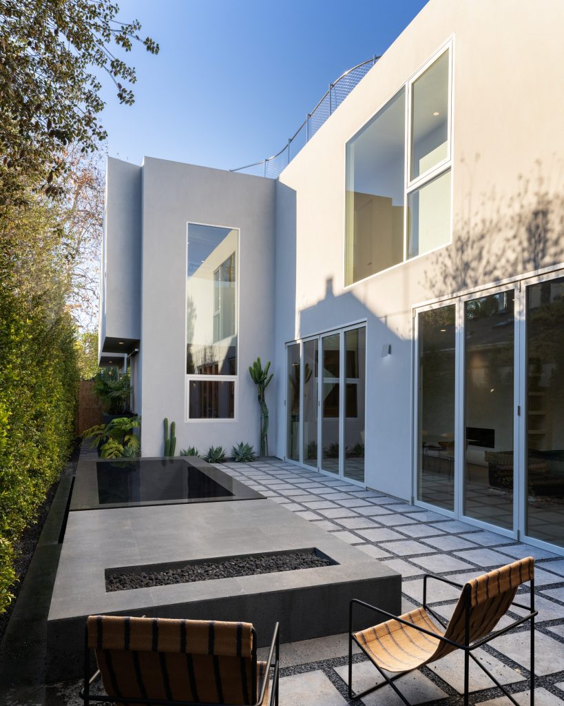 Radius House – Dvorišče z bazenom ob zastekljenih bivalnih prostorih.
