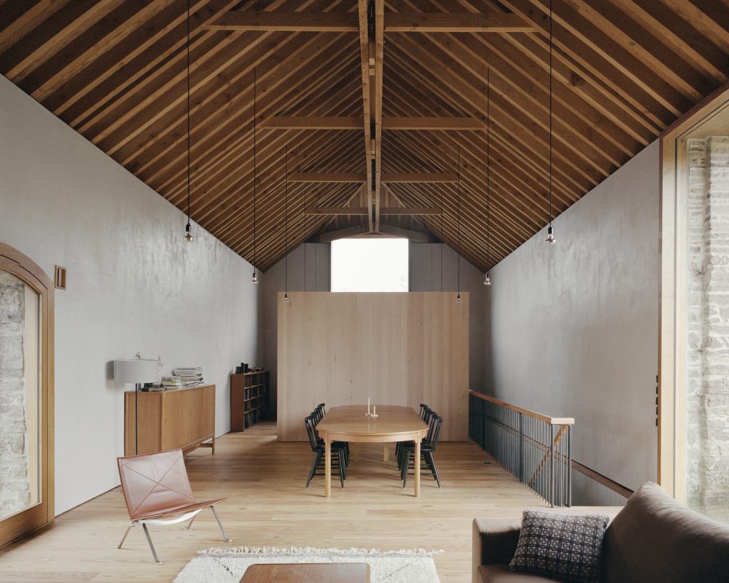 Redhill Barn – Odprt družabni prostor pod leseno strešno konstrukcijo.
