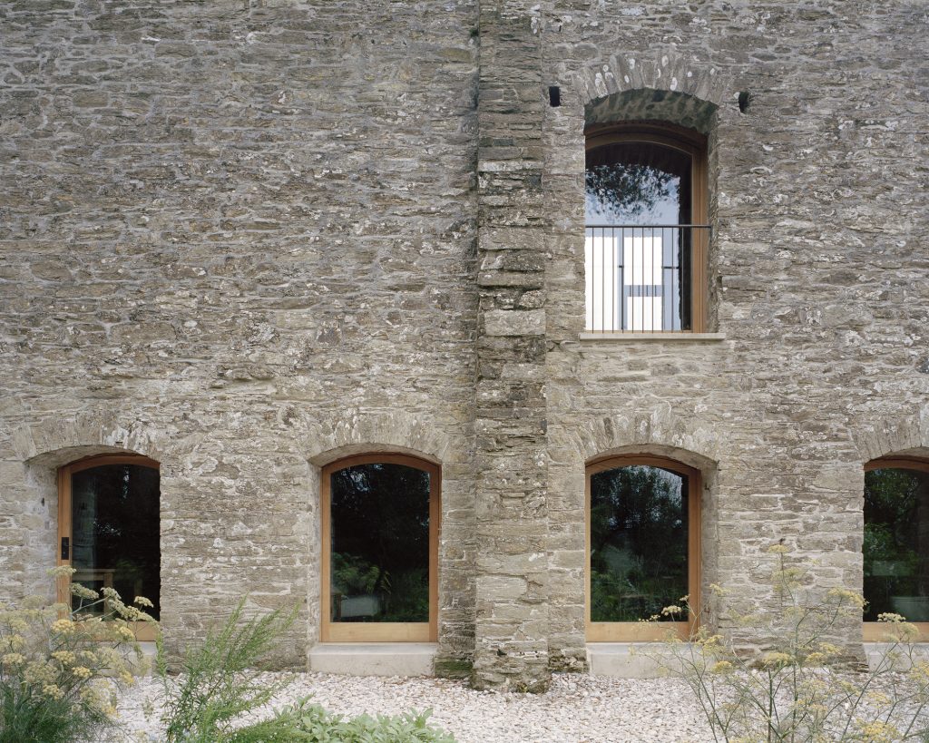 Redhill Barn – Ohranjene obokane odprtine kamnite fasade.