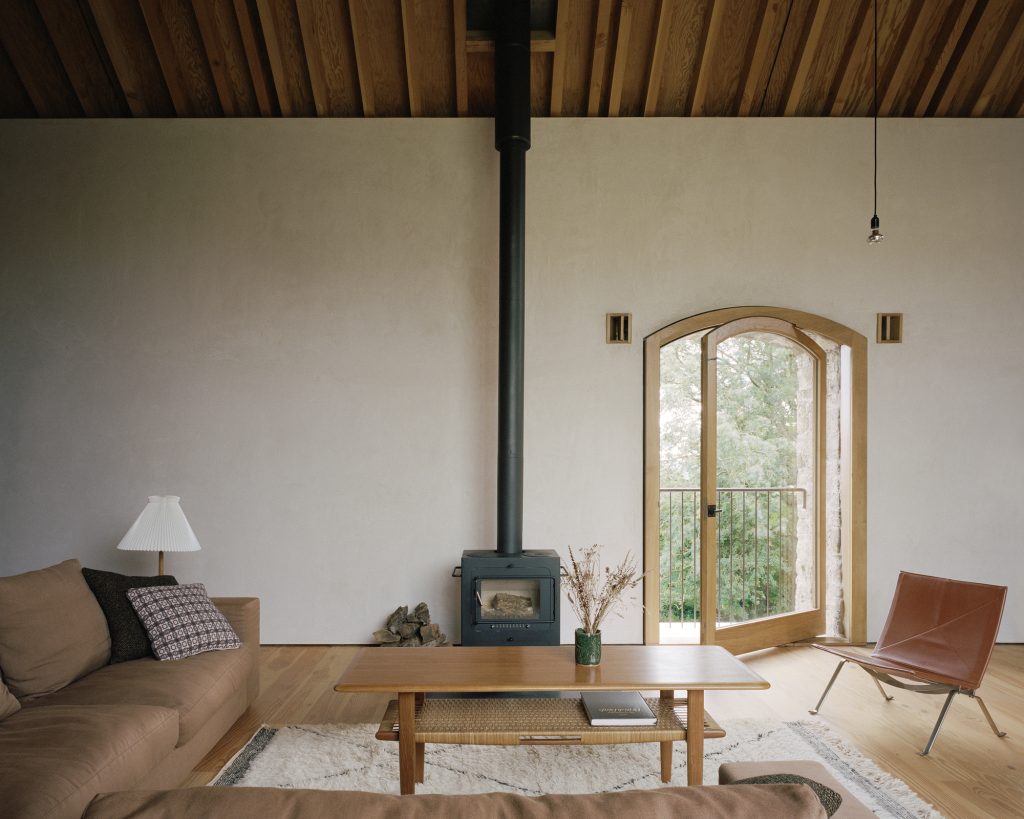 Redhill Barn – Sedišče ob peči in obokanem oknu.
