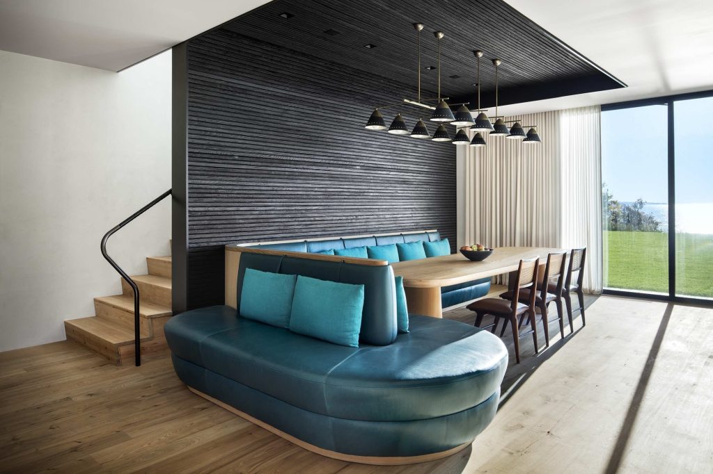 Shore House – Jedilnica ob temni leseni steni in velikem oknu.